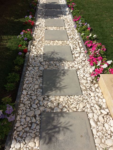 Cement Block Tiles Bordered By White Pebbles For A Simple Pathway