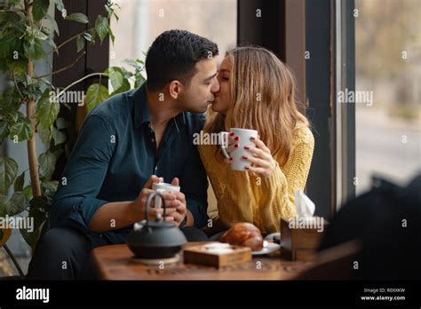 Young Attractive Couple Kissing On Date In Coffee Shop In Love Man And Woman Sitting In A Cafe