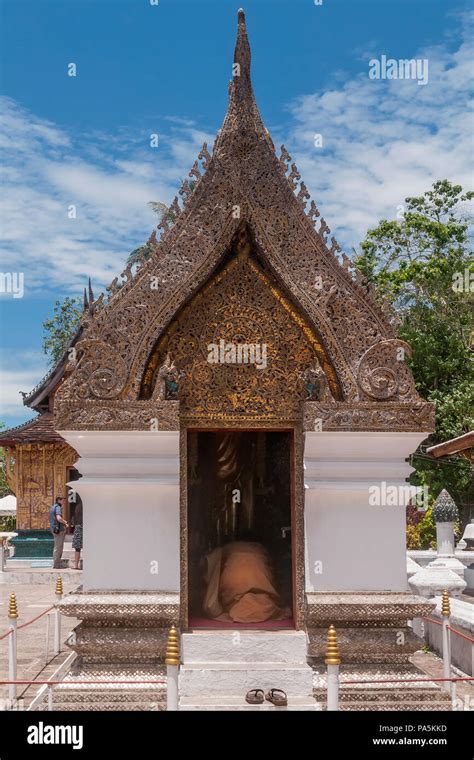Buddhist Monk Prays Kneeling In A Shrine Inside The Wat Xieng Thong
