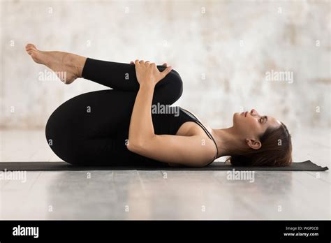 Beautiful Woman Practicing Yoga Knees To Chest Pose Apanasana