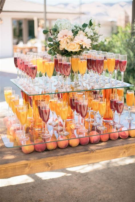 A Table Topped With Lots Of Glasses Filled With Wine And Peaches On Top