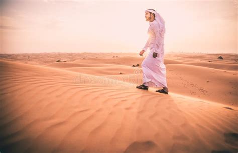 Arabic Man With Traditional Emirates Clothes Walking In The Desert