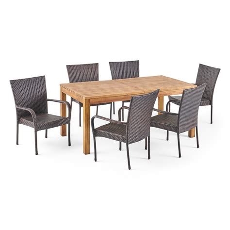 An Outdoor Dining Table And Chairs Set With Wooden Top Wicker Backrests