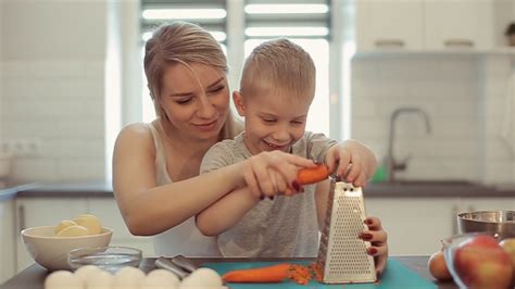 Mom Teaches Son To Rub Carrot They Are Laughing A Young Beautiful
