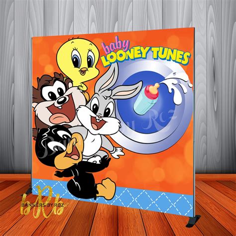 The Loony Tunes Sign Is On Display In Front Of A Wooden Wall With Wood