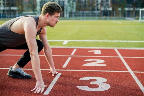 Joven Atleta Masculino Listo Para Correr Tomando Posición En La Línea