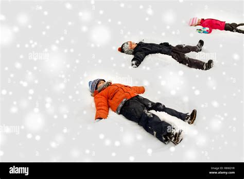 Happy Little Kids Making Snow Angels In Winter Stock Photo Alamy