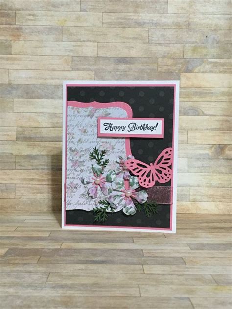 A Birthday Card With Flowers And A Butterfly On The Front Sitting On A