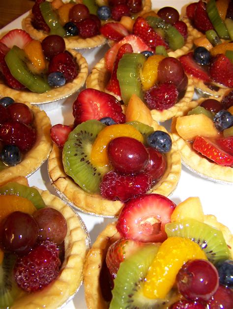 Many Different Kinds Of Fruit Pies Are Arranged On A White Platter And