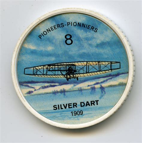A Round Tin With An Image Of A Silver Dart Airplane On Its Side