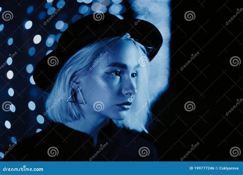 Millennial Enigmatic Pretty Girl Blond Hairstyle Near Blue Glowing Neon