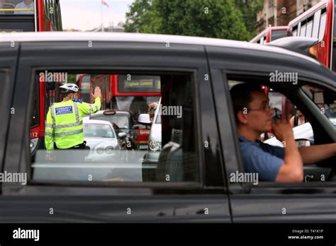 police community support officer directing heavily congested traffic during rush hour london