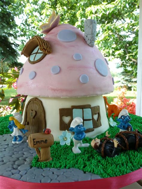 The Cake Is Made To Look Like It Has A Pink Mushroom House And Blue Flowers