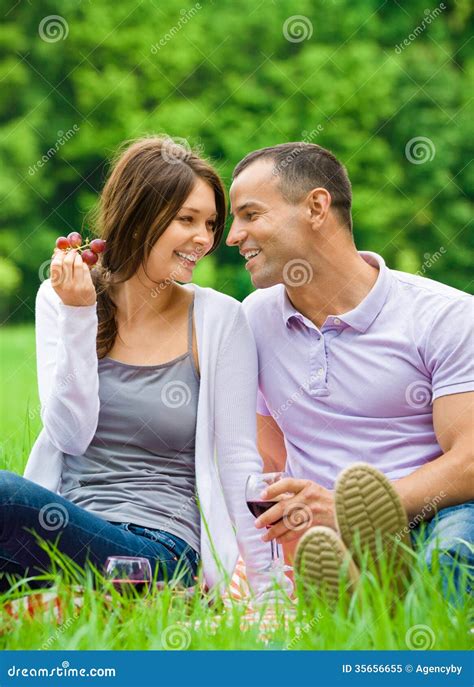 Woman And Man Sit On Grass In Park And Eat Grape Stock Image Image Of