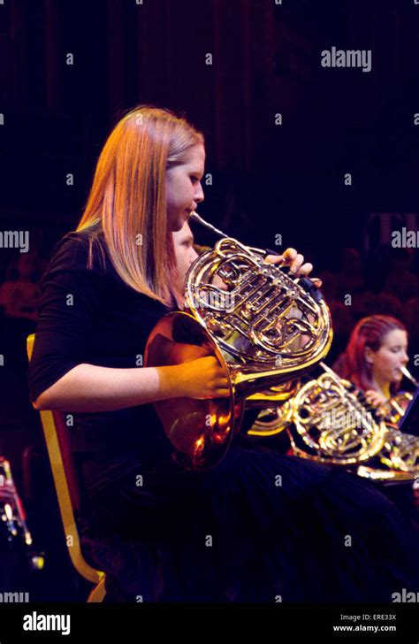 Female French Horn Player Playing In A Youth Symphony Orchestra At One