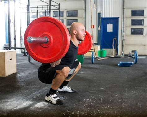 Adding weight to a barbell. WatchFit - Beginner's Guide to Weight Lifting Like a Pro