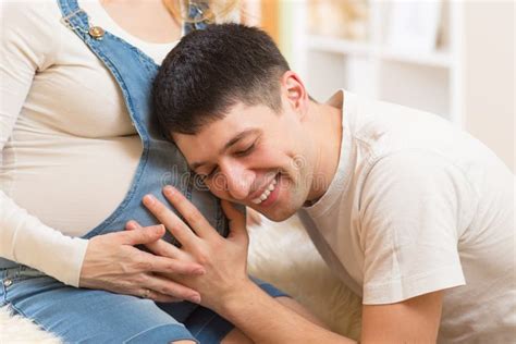 Hombre Feliz Que Escucha El Vientre De Su Esposa Embarazada Imagen De