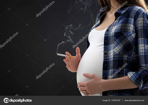 Mujer embarazada fumando cigarrillo fotografía de stock belchonock