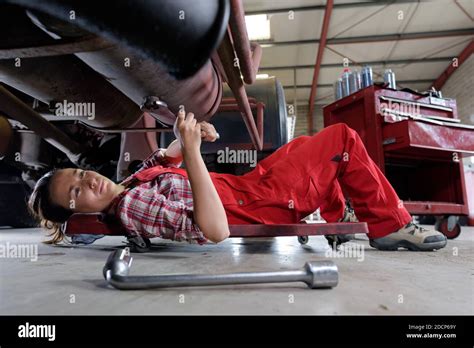 Portrait Of Female Auto Mechanic Working Underneath Car Stock Photo Alamy
