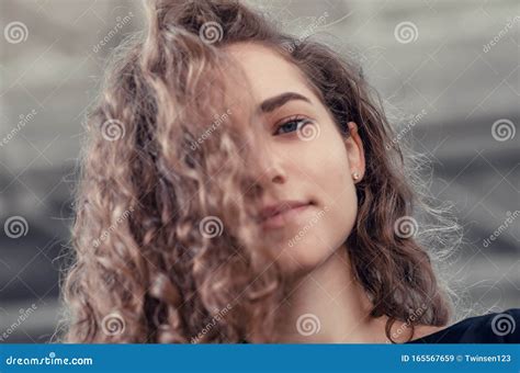 Portrait Of A Cute Girl With Long Curly Hair Looking Down At Camera Nice Smile Stock Image