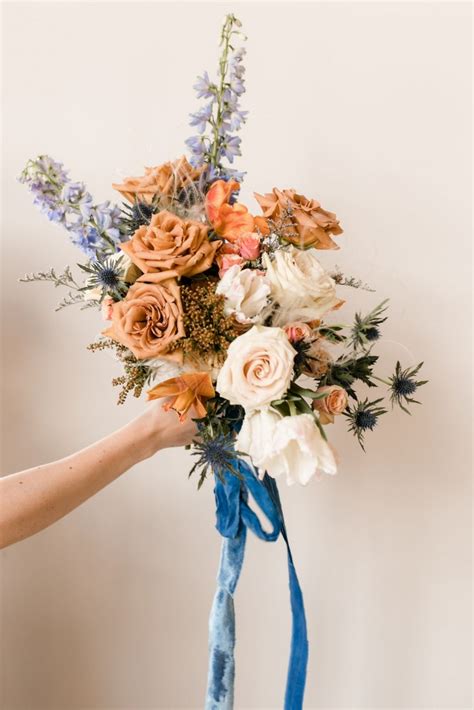 Bridal bouquet with fresh and dried flowers in terracotta, blush, and ...
