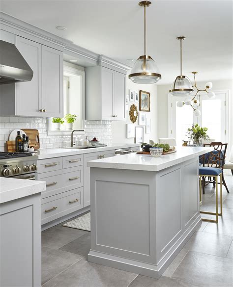 While you do want lighter colors to balance the darker cabinets, you don't want to make the. Light Grey Kitchen with celestial chandelier over the kitchen table + white quartz countertops ...