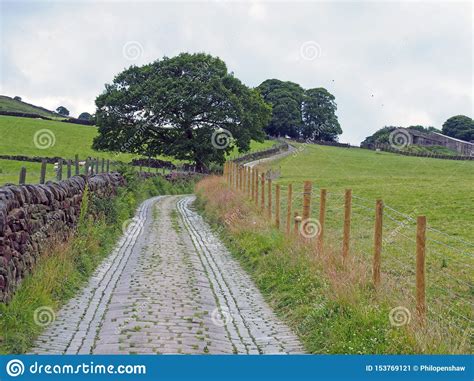 Narrow Cobble Stone Winding Country Lane Surrounded By Stone Walls