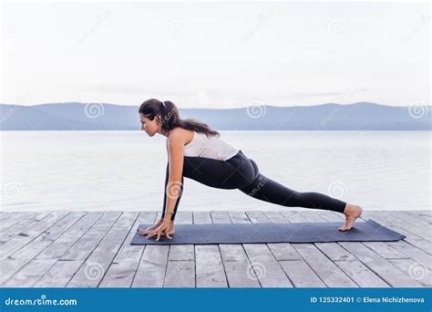 Young Attractive Smiling Woman Practicing Yoga On A Lake Stock Image