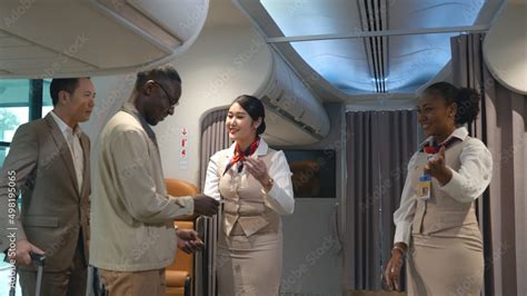 Foto Stock Asian Flight Attendants Greeting Welcoming Passengers