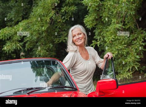 Cheerful Mature Woman Getting Off Her Convertible Stock Photo Alamy