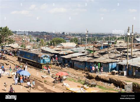 A Train Locomotive Drives Through Kibera Slum As Residents Go About