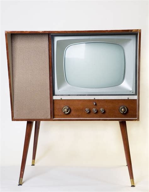 An Old Fashioned Tv Sitting On Top Of A Wooden Stand In Front Of A