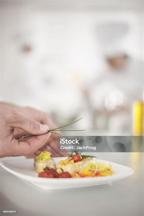 Closeup On Chefs Hands Garnishing A Plate Stock Photo Download Image