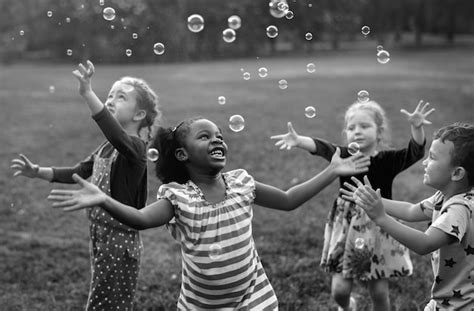 Niños Jugando Burbujas En Un Parque Foto Premium