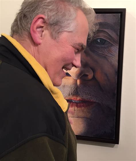 An Older Man Looking At A Painting On The Wall