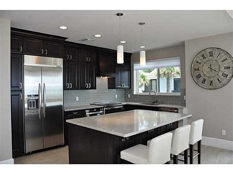 This question may arise when coordinating with the design and flow of your kitchen. gray tile plank floors with espresso cabinets, long handle ...
