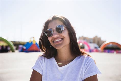Free Photo Smiling Portrait Of A Young Woman Wearing Sunglasses