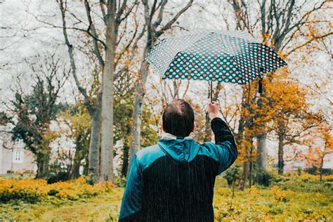 Photo Of Man Holding Umbrella While Raining · Free Stock Photo