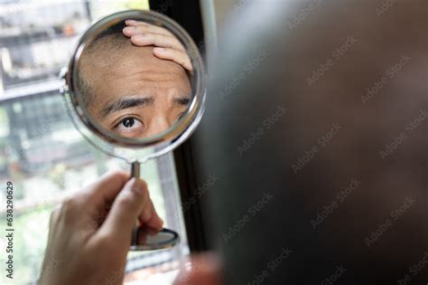 Cropped Shot View Of Asian Man Worry About His Hair Loss After Saw The Problem By A Mini Mirror