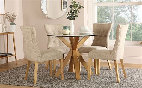 Legs are made of stainless steel in a silver color. Hatton Round Oak and Glass Dining Table with 4 Bewley Oatmeal Fabric Chairs | Furniture And Choice