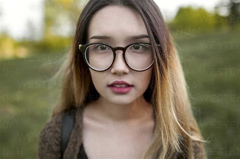 Asian Teenage Girl Wearing Eyeglasses In Field Stock Photo