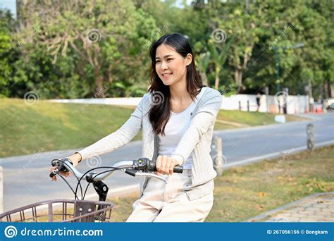 Beautiful Young Asian Woman Enjoys Riding A Bicycle In The Beautiful