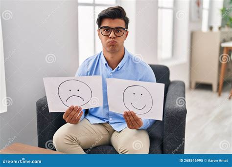 Hispanic Man Working On Depression Holding Sad To Happy Emotion Paper