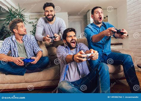 Male Friends Playing Video Games At Home And Having Fun Stock Photo