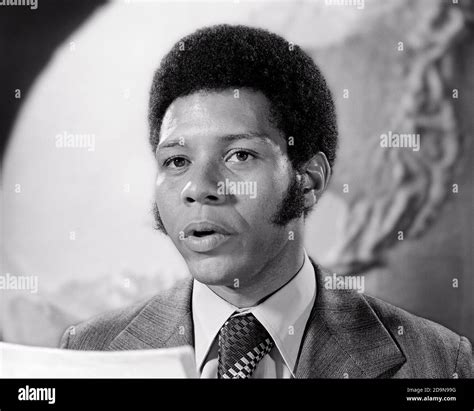 1970s African American Man Newscaster Looking At Camera Giving Reading