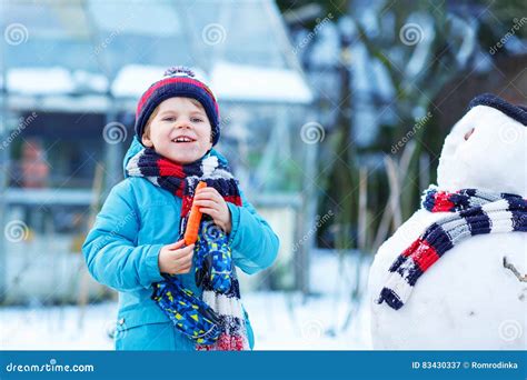 Funny Kid Boy Making A Snowman In Winter Outdoors Stock Image Image