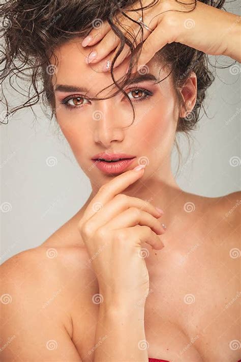 Busty Model Touching Her Face While Fixing Curly Hair Stock Image