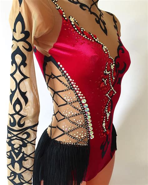 A Woman In A Red And Black Leotard With An Elaborate Design On It