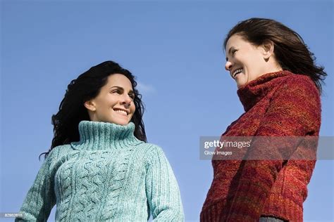 Low Angle View Of Two Mature Women Standing Together And Smiling Photo
