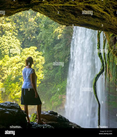 Tourist In Cave Looking Out At Misol Ha Waterfall Near Palenque In